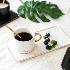 Rinkinys desertui: kavos puodelis su lėkštute ir šaukšteliu